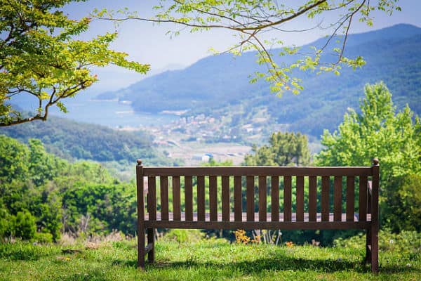 Park bench overlooking mountains. An ideal place for Pausing and Procrastinating Toward Progress