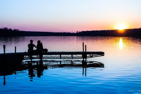 couple at end of pier at sundown