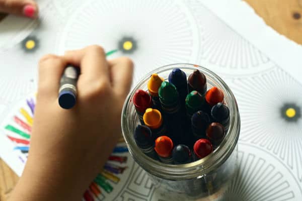 pot of crayons and child colouring