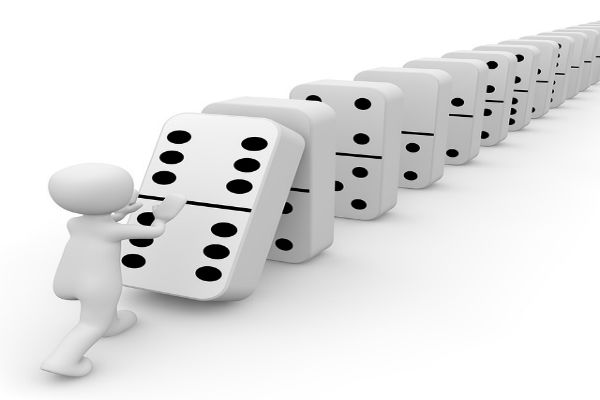figure pushing over dominoes
