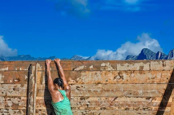 woman in running gear holding on to wall