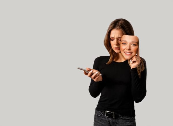 sad woman holding happy face mask representing false image on social media