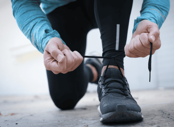 man tying running shoes